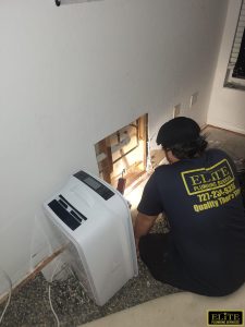Technician inspecting wall for plumbing leak