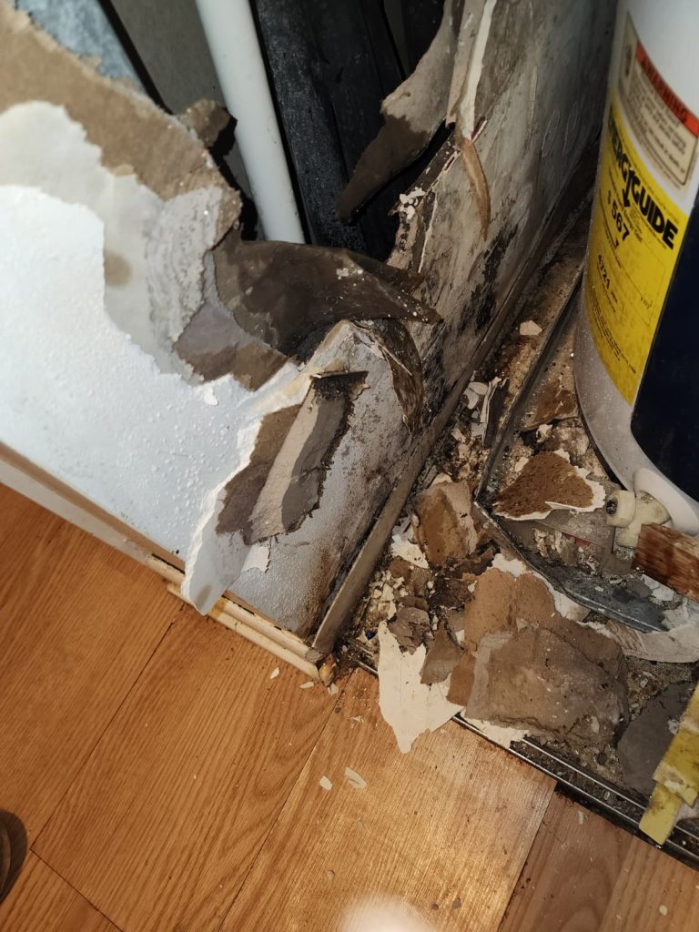 water heater closet wall water damage closeup.jpeg